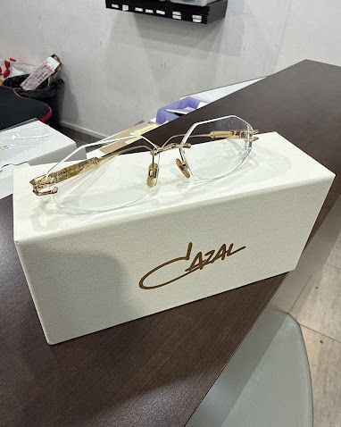 Monture Cazal dorée sans cercle posée sur son étui, dans la boutique Optical Confort