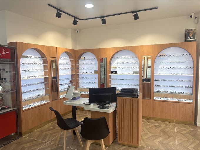 Intérieur de la boutique Optical Confort : montures de vue dans des niches en arche éclairées et bureau de conseil