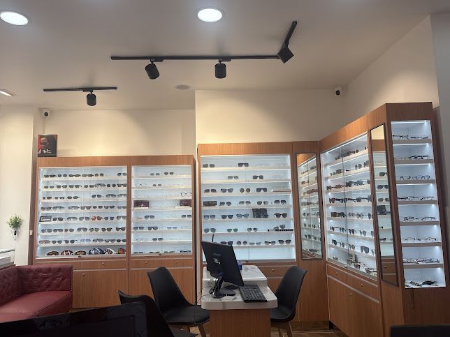 Murs de lunettes de soleil éclairés et canapé dans la boutique Optical Confort
